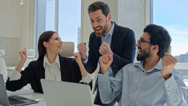 Happy creative team celebrate victory in office successful sales stock market data online business people businessmen and businesswoman winning teambuilding corporate teamwork with documents laptop - Powered by Adobe