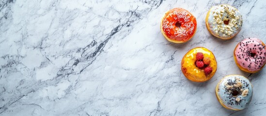 Assorted donuts on marble background with diagonal arrangement and copy space on left