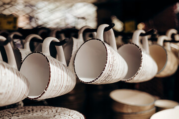 Shelf with ceramic cups and plates for sell in a tableware store.