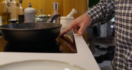 A man sets up a stove for frying. Close-up of his hand, an unrecognizable person