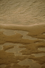 A tranquil beach scene that beautifully showcases gentle ripples and warm, inviting sandy hues...