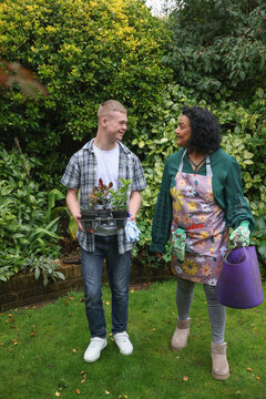 Mature mother with adult son standing in garden