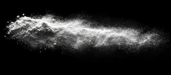 White powder explosion on black background with dynamic motion effect and particle dispersion