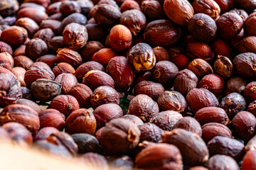 A bunch of coffee nuts are spread out on a green surface.