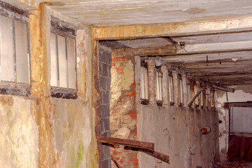 Piwnice opuszczonego, zniszczonego budynku przemysłowego zbudowanego z cegieł, pustaków i stali. Stary opuszczony budynek dla entuzjastów eksploracji miejskiej (urbex). Malutkie okienka piwniczne . © Grzegorz