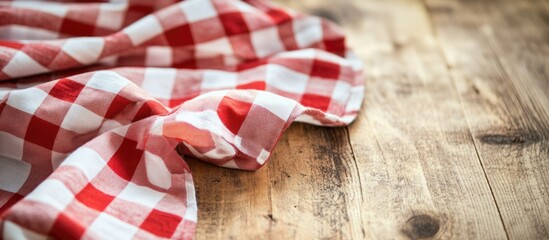 Obraz premium Red and white checkered fabric on rustic wooden table with copy space