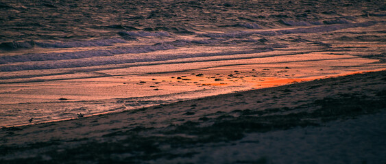 Serene Coastal Sunset Reflection on Silky Sand and Gentle Ocean Waves