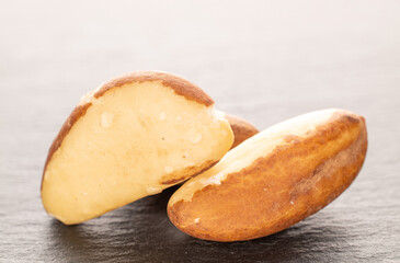 Several Brazil nuts on slate stone, macro.
