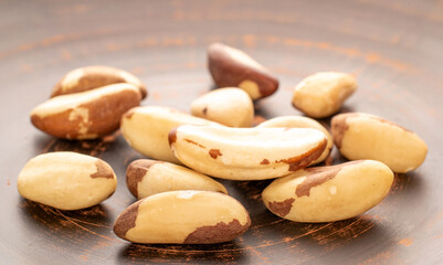 Several Brazil nuts on a clay plate, close-up.