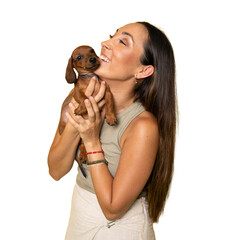 Young woman hugs her puppy Dachshund dog and looks at it. Love between dog and owner. Isolated on...