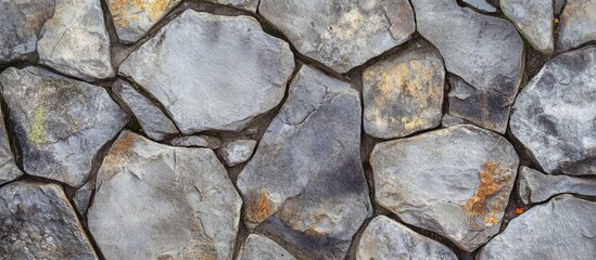 Obraz premium Textured stone wall background with various shapes and colors of natural stones in an irregular arrangement. Copy Space