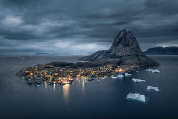 Aerial night view of Uummannaq island with enlightened houses and floating giant icebergs. Northwest Greenland, autonomous territory of Denmark.  © Ji