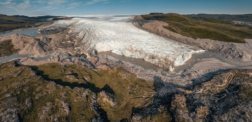 Panoramic aerial view of Russel's glacier with a glacier river stretching into tundra during a sunny day near Kangerlussuaq.  Southwest Greenland, autonomous territory of Denmark. 