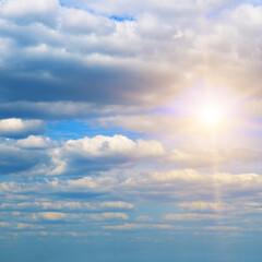 Blue sky with clouds and bright sun.