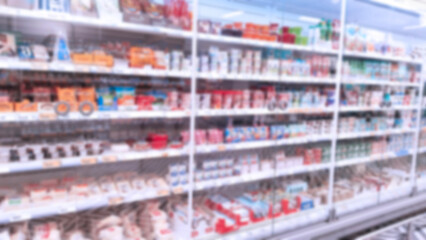 Abstract blur image of supermarket background. Defocused shelves with dairy products. Grocery shopping. Store. Retail industry. Food quality. Rack. Discount. Inflation and crisis concept. Aisle. CPG.