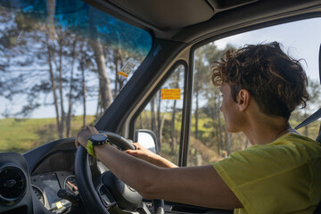 Woman driving modern van through green new zealand countryside