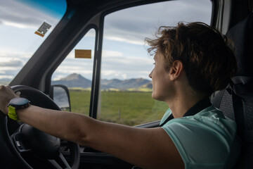 Woman driving modern van through green new zealand countryside