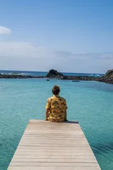 Photo sur Plexiglas Tourist relaxing on a wooden pier in fuerteventura, canary islands, spain