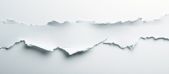 Torn edge of white paper on a smooth gray background with textured details and ample copy space for text insertion