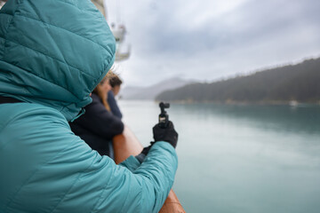 Tourist filming new zealand fjord landscape with gimbal from cruise ship