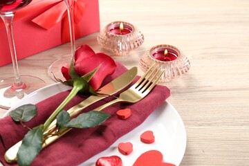 Romantic place setting with red rose on white table, closeup. Valentine's day celebration