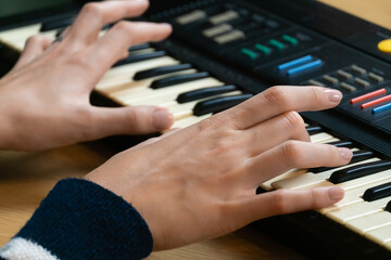 Obraz premium Close-up view of female hands skillfully playing an electronic keyboard, highlighting the intricate art of music creation and the passion that drives musical expression
