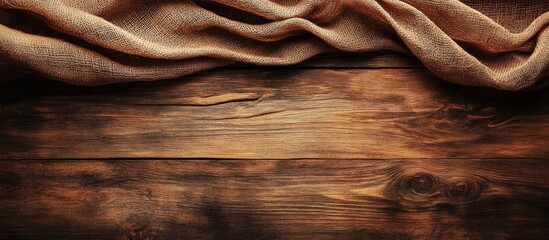 Textured fabric draped on rustic wooden surface with natural grain patterns and copy space for text placement