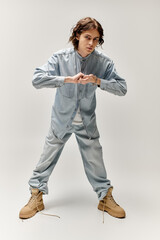 Handsome young man strikes a bold pose in trendy denim attire, showcasing personal style and flair.