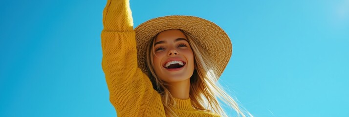 A joyful young woman celebrates the warmth of summer under a clear blue sky, wearing a straw hat and a cheerful yellow sweater, embodying the essence of summer vacation and travel.