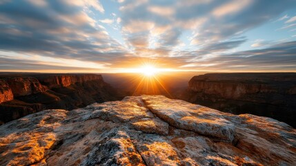 Naklejka premium A breathtaking sunset illuminates the Grand Canyon with vibrant orange and yellow hues, showcasing the layered rock formations and vast landscape in all its glory.