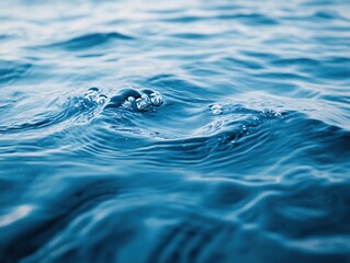 Blue water surface with small waves and bubbles close up view aquatic nature background