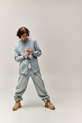 Fototapeta premium Young stylish man stands confidently in relaxed denim attire, exuding urban fashion vibes.