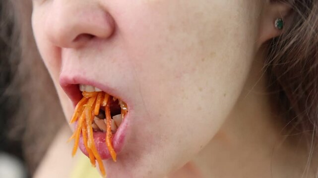 Close-up portrait of woman eating carrot. Eating vegetables. Close-up of woman eating carrot.