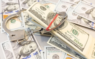 Pair of metal police handcuffs on Euros banknotes money cash background. Corruption, dirty money, gambling or financial crime ideas concept.