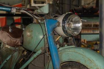Facade of old rusty motorcycle with vintage headlight close-up. © IhorStore