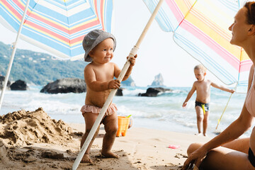 Photo of happy little girl playing on beach near ocean.