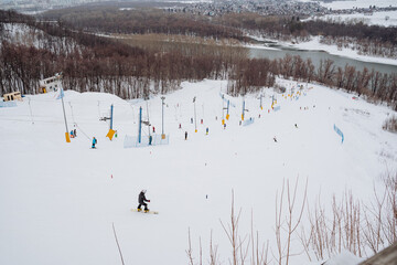 An individual gracefully glides down a snowy slope, relishing the beauty and thrill of winter,...