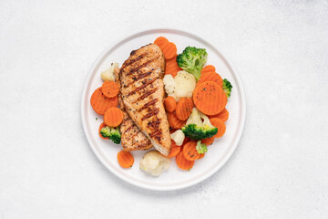 Grilled chicken breast and broccoli, cauliflower and carrots. Chicken meat with vegetables. Healthy food. White background top view