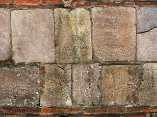 Ancient stone wall with red bricks as background