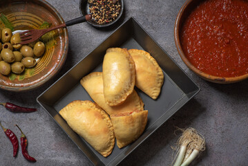 Golden Empanadas with Salsa on a Wooden Board