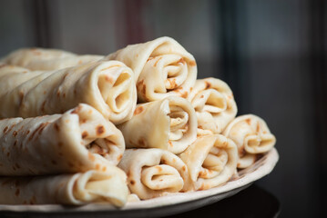 Stack of rolled crepes served on a plate