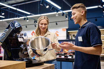 A Sales Associate showcases a kitchen appliance to customers, emphasizing its features