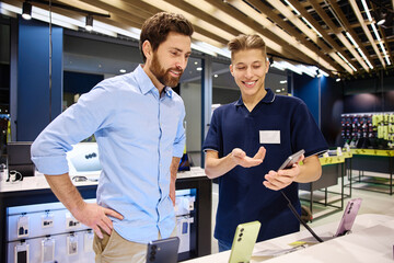A friendly interaction occurs between a salesperson and a customer in a smartphone store