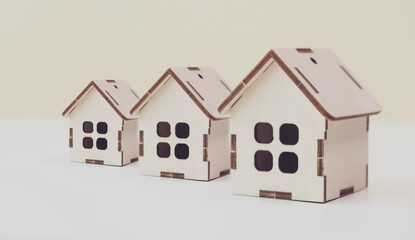 three wooden houses on a light background
