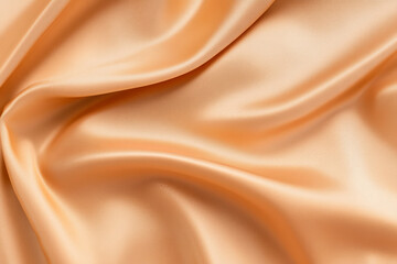 Fototapeta premium Photorealistic close-up of smooth, shimmering peach fabric showcasing soft textures and intricate folds