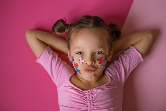 The girl decorated cheeks with an autism symbol and sends an air kiss as a sign of support and concern for people with autism spectrum disorder. - Powered by Adobe