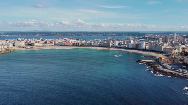 A Coruna, Spain, aerial drone perspective. Panoramic view of all city. Drone descending and camera tilt up. Travel destination in Galicia. A Coruna harbour in background, large cruise ship docked