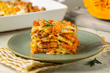 Plate with Pumpkin, cheese and sausage lasagna. Italian Baked pasta in casserole, homemade food.
