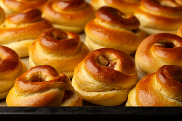 Cooking tray with just baked swirl shape apple cinnamon buns. Food background. Homemade yeast bakery.
