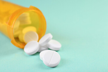 Medical bottle with antibiotic pills on yellow background, closeup. Space for text